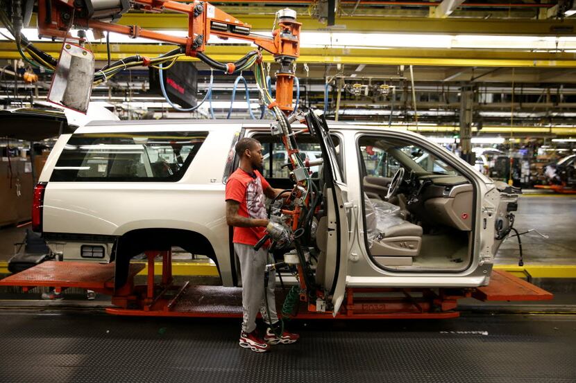 Jordan Taylor attaches a door to a Suburban being built at General Motors Assembly Plant in...