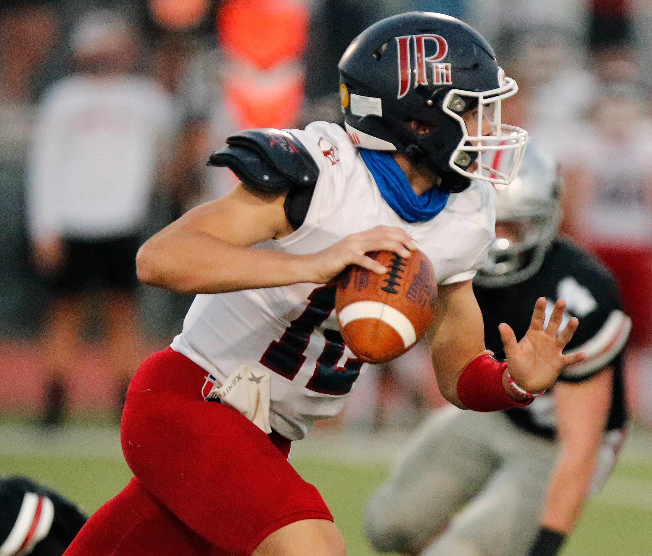 John Paul II High School quarterback Drew Forkner (12) scrambles before running with the...