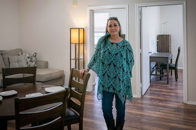 Tonia A. stands in the living room of her apartment at the sober living facility Tillman House.