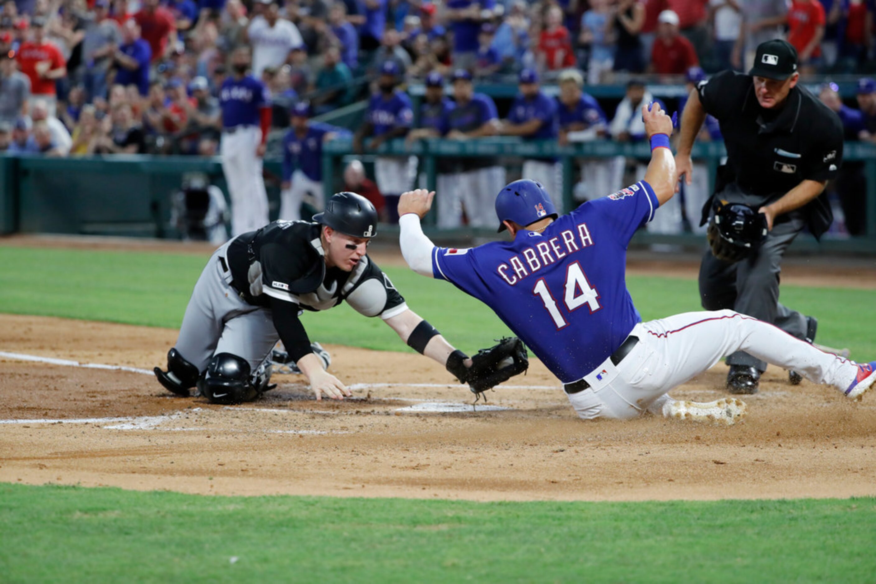 Chicago White Sox catcher Zack Collins (38) reaches down to tag out Texas Rangers' Asdrubal...