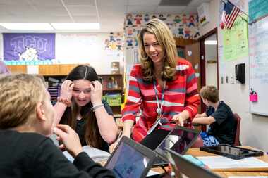 Medlin Middle School teacher Kristy Butler helps Addyson Morgan, 12, center, and Ashlyn...