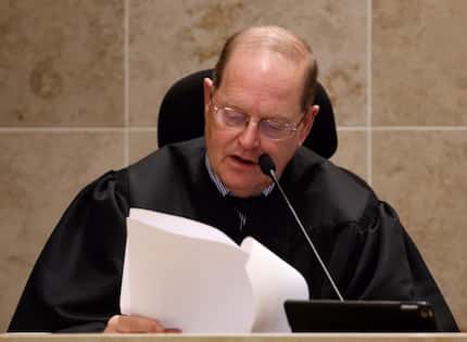 District Judge Mark Rusch reads the charge to the jurors during the trial of Enrique Arochi...