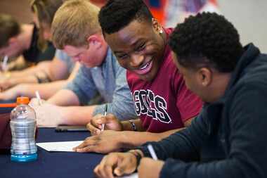 McKinney North defensive lineman Justin Madubuike, second from right, smiles at his...