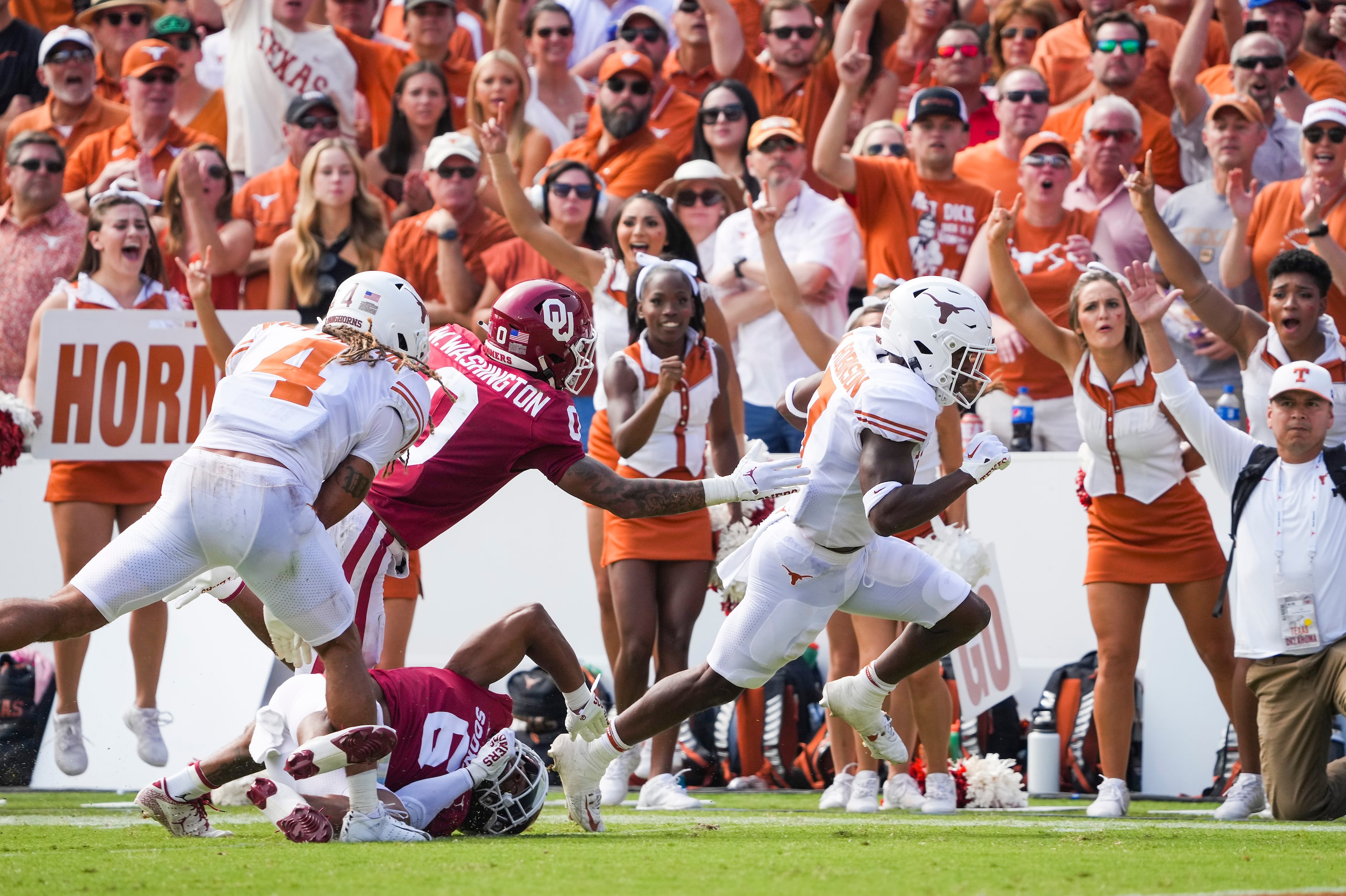 Texas running back Keilan Robinson (7) gets pas Oklahoma defensive back Trey Morrison (6)...