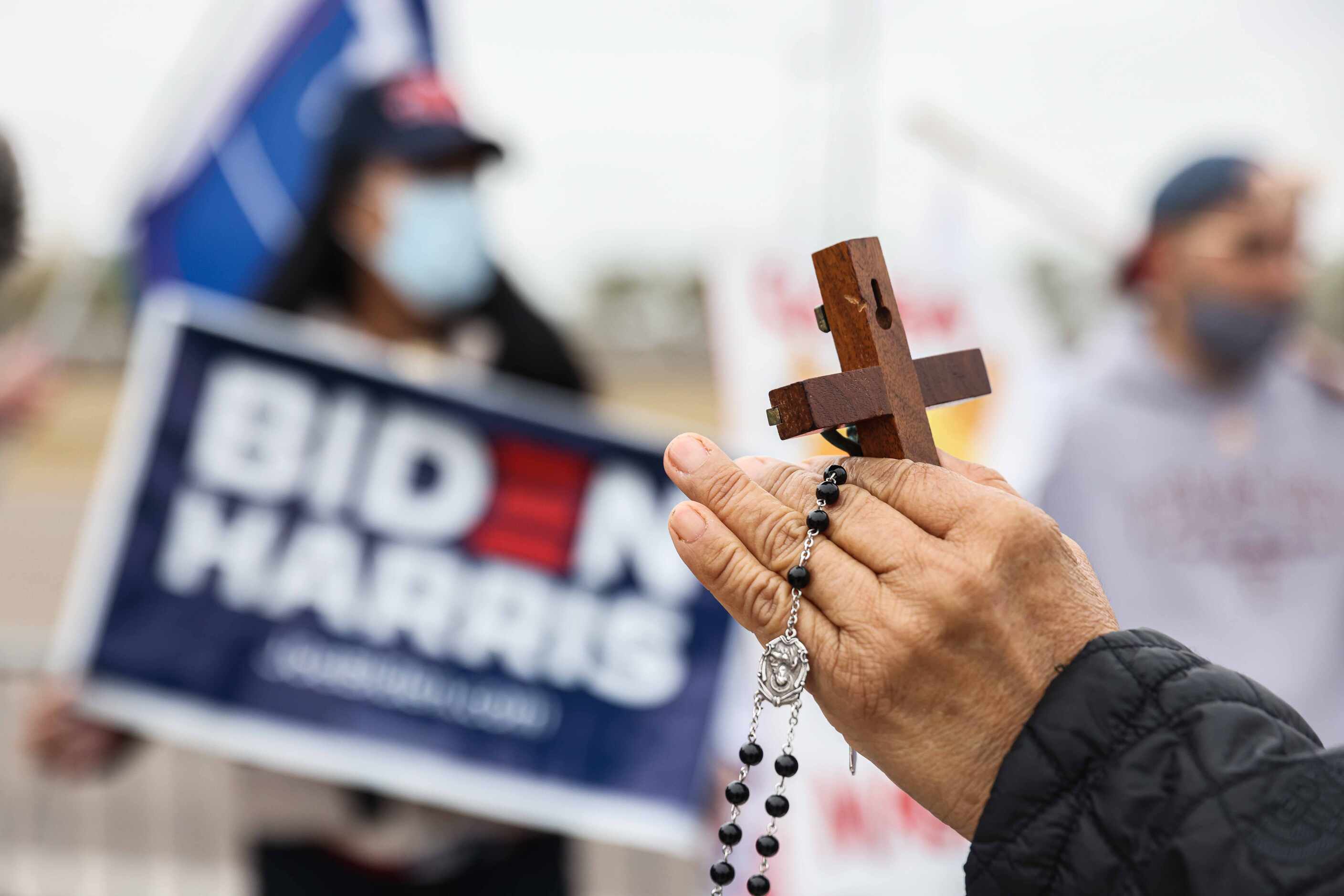 A woman holds a cross in her hand as she confront Marsha Lee Martinez who holds a...