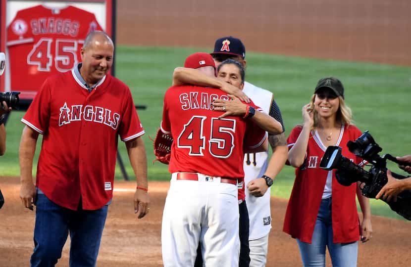 Debbie Hetman hugs catcher Andrew Heaney #45 of the Los Angeles Angels as stepfather Danny...