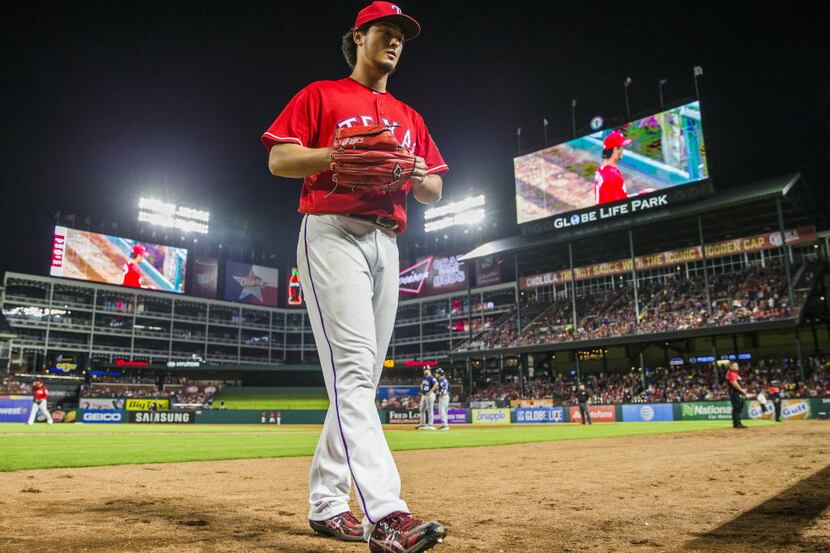 Texas Rangers starting pitcher Yu Darvish (11) walks to the dugout after being pulled from...
