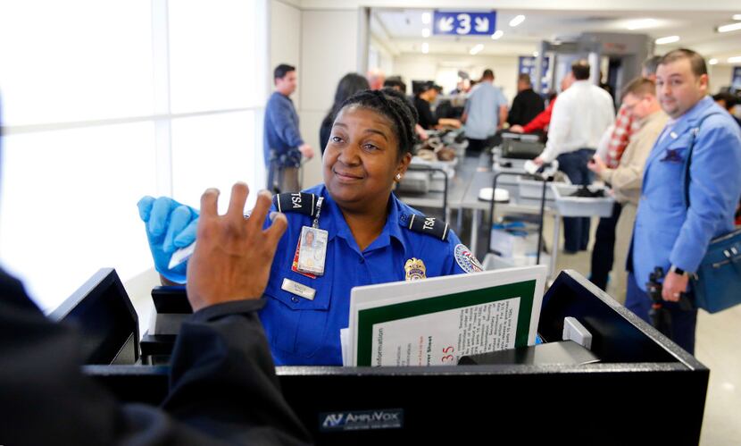 TSA agent Michelle Bender checks a person's license at the newly renovated security...