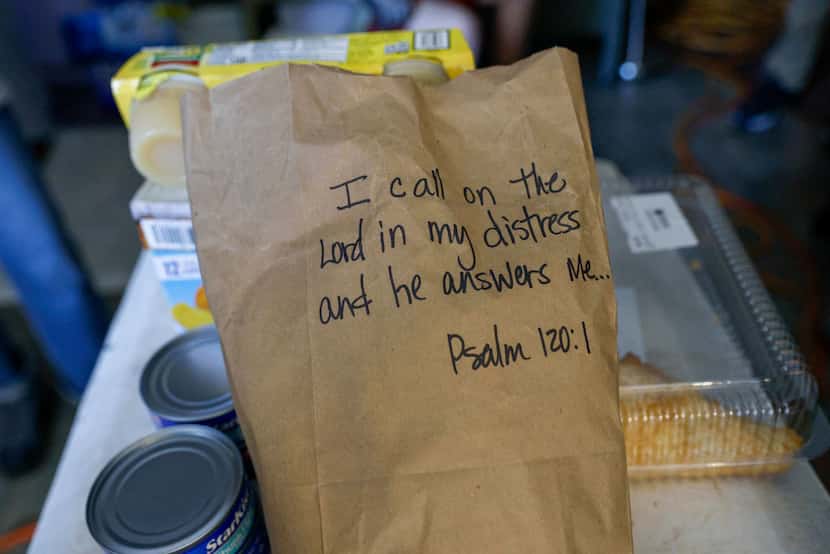A bible scripture is seen on a bag of food donated by a local church inside the home of...