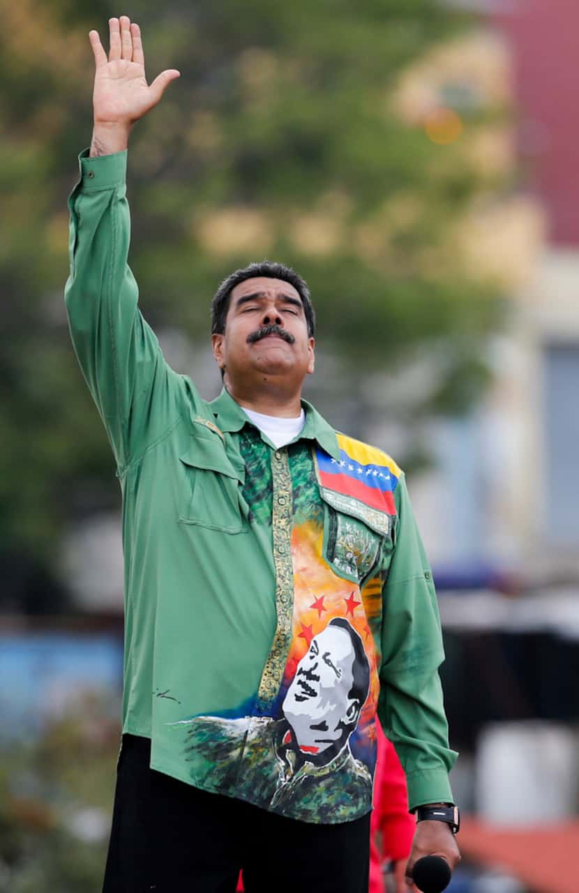 Venezuela's President Nicolas Maduro holds his hand up during his closing campaign rally in...