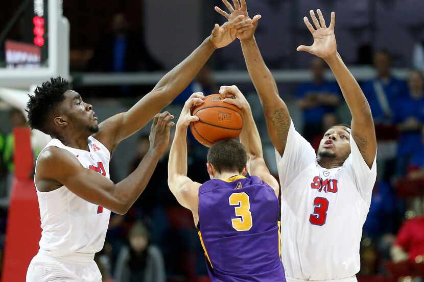 Albany guard Joe Cremo (center) is defended by SMU guard Shake Milton (left) and guard...