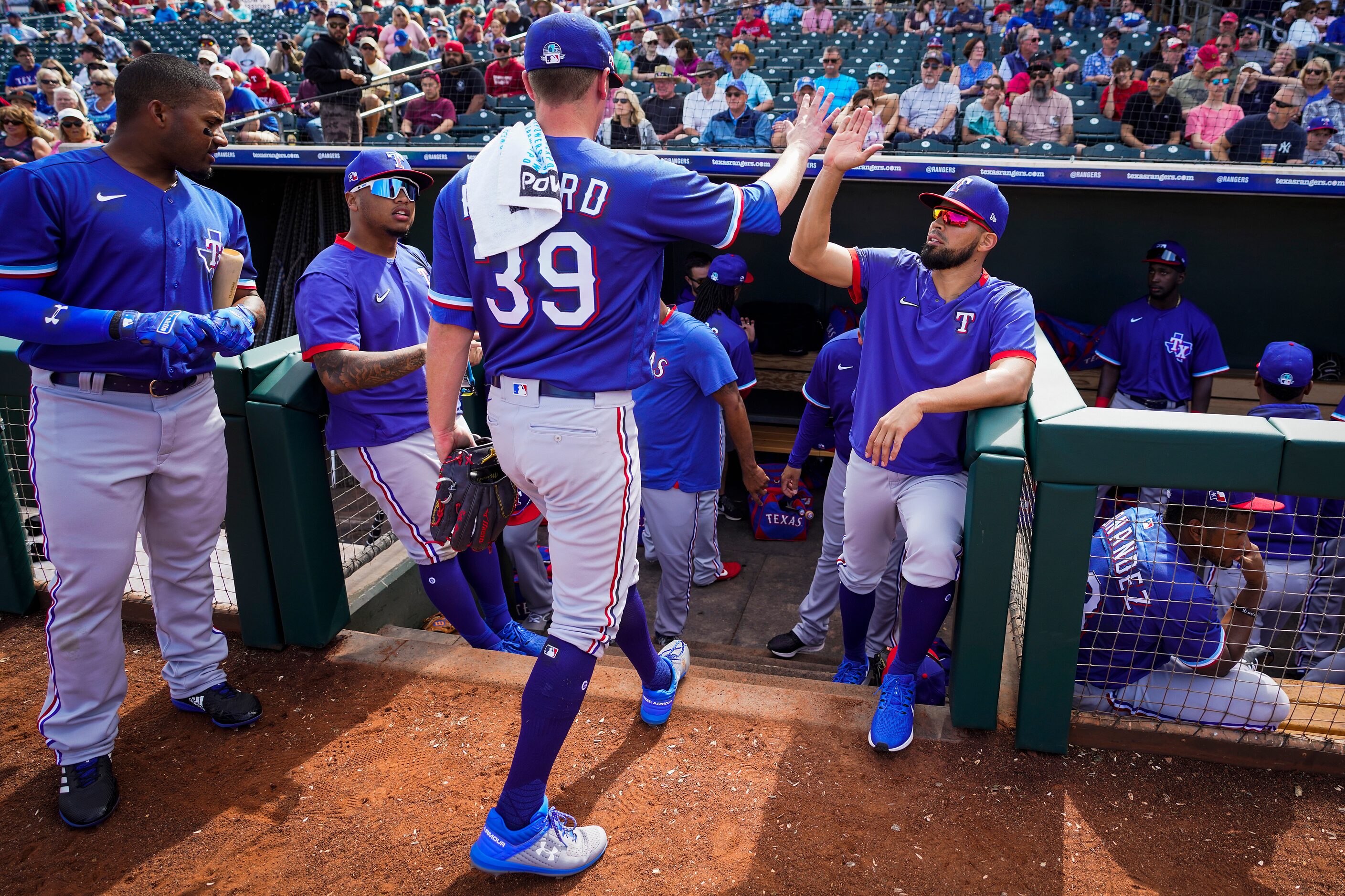 Texas Rangers starting pitcher Kolby Allard high fives catcher Robinson Chirinos (right)...