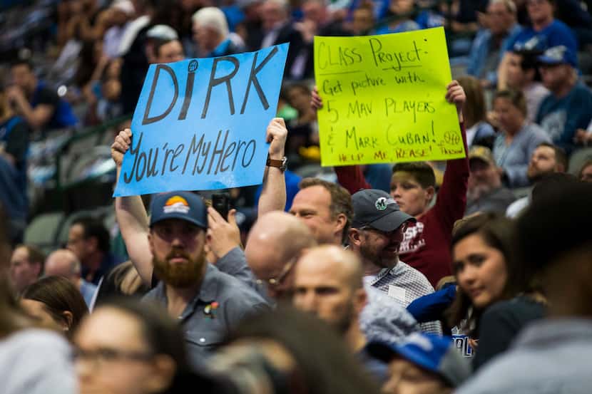 Fans of Dallas Mavericks forward Dirk Nowitzki (41) hold up signs during warmups before an...