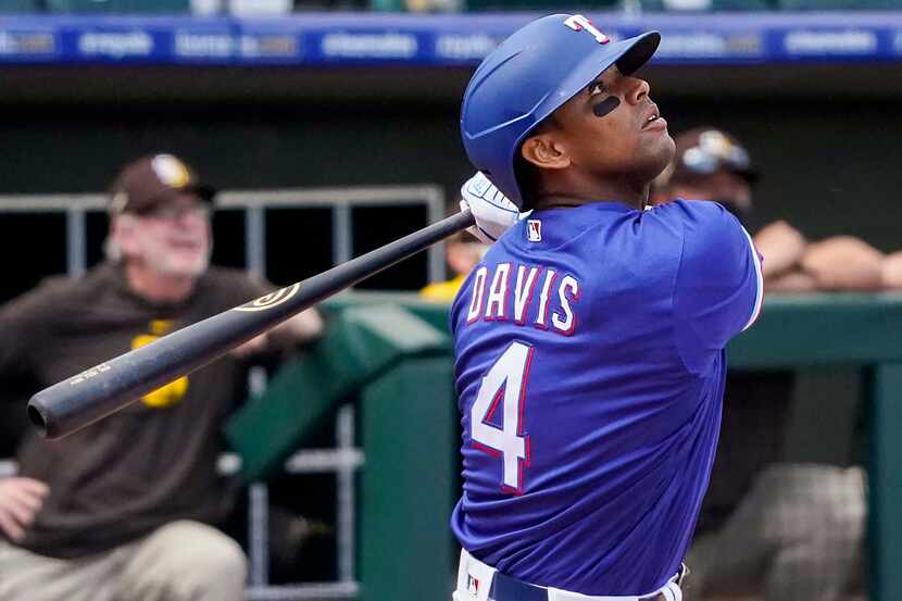 Texas Rangers designated hitter Khris Davis watches the ball as he flies out to right field...
