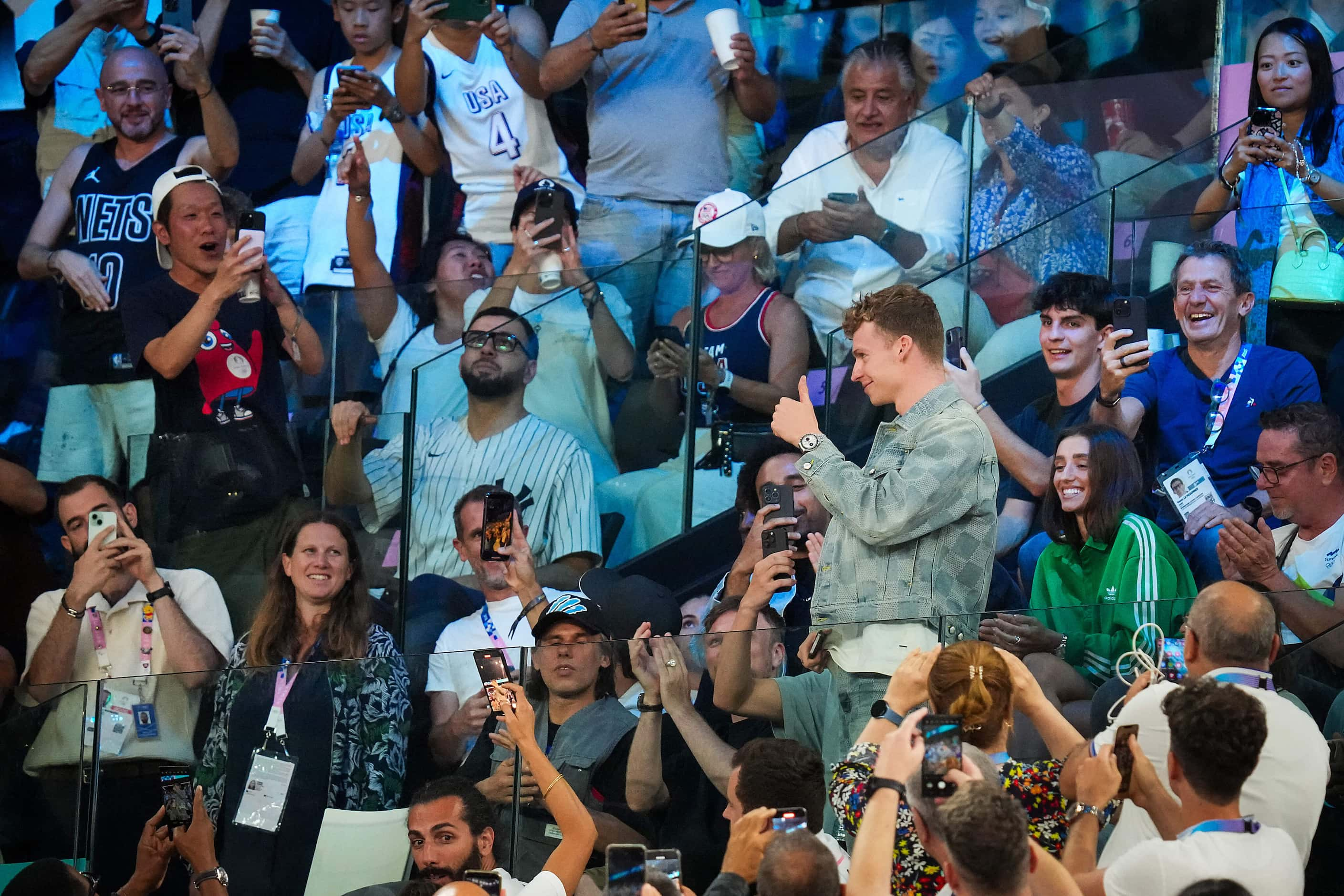 French swimmer Léon Marchand gives a thumbs up to the crowd during a men’s basketball...