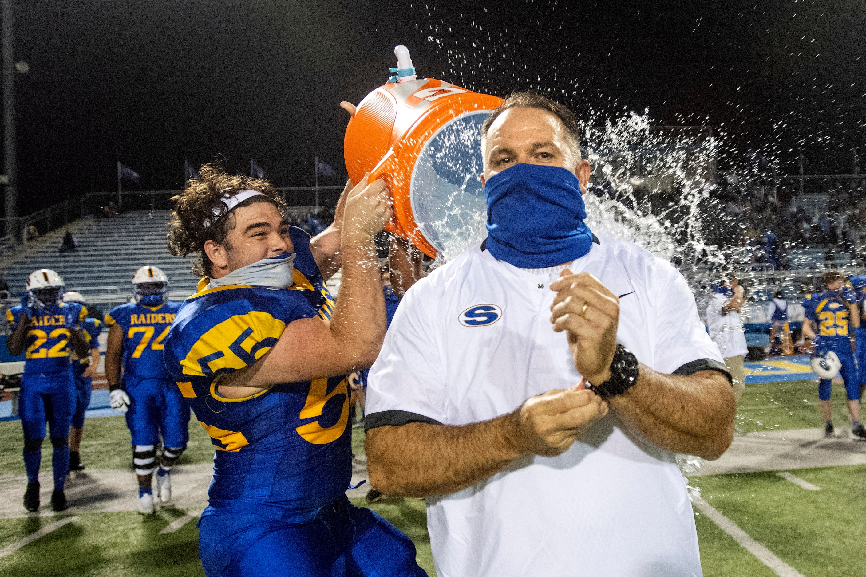 Sunnyvale head coach John Settle receives a celebratory dousing from senior offensive...