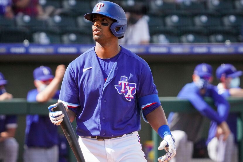 Texas Rangers designated hitter Khris Davis heads back to the dugout after striking out...