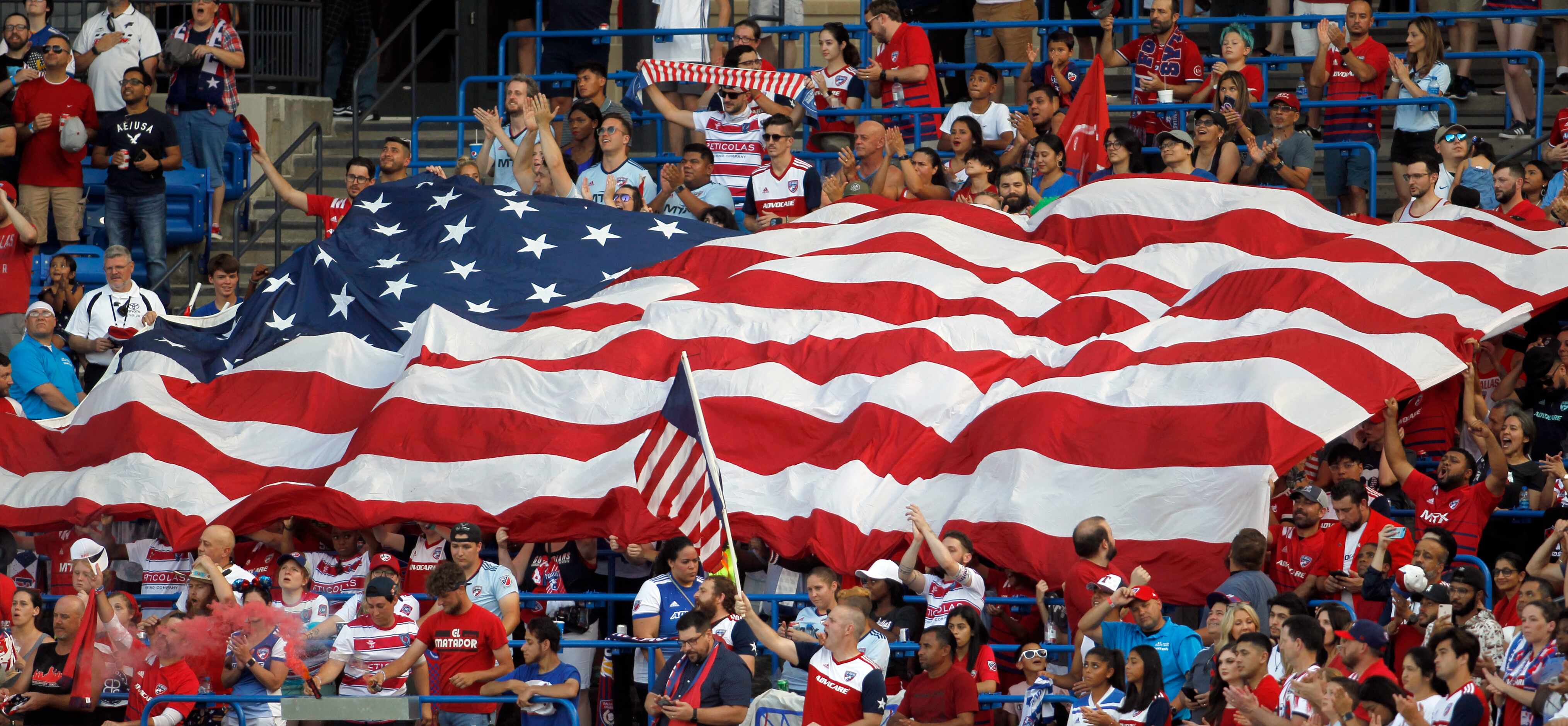 FC Dallas fans frame a Texas-sized American flag in the stands during the playing of the...