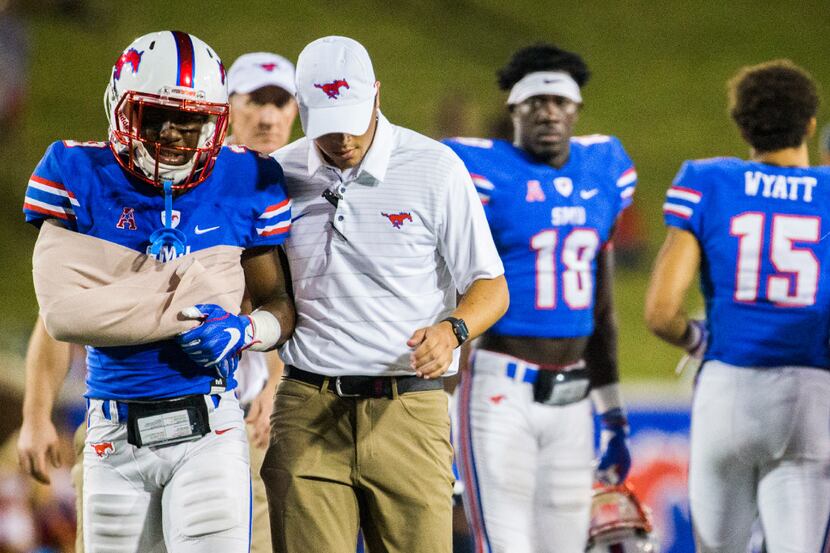 Southern Methodist Mustangs defensive back Cedric Lancaster (3) is escorted off the field...
