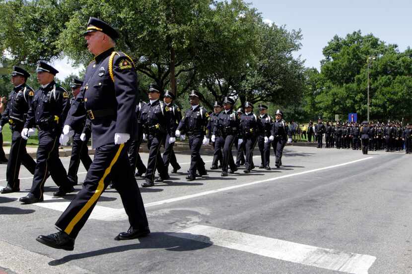 Dallas police officers march up Young St. to the annual Dallas Police Memorial Service,  