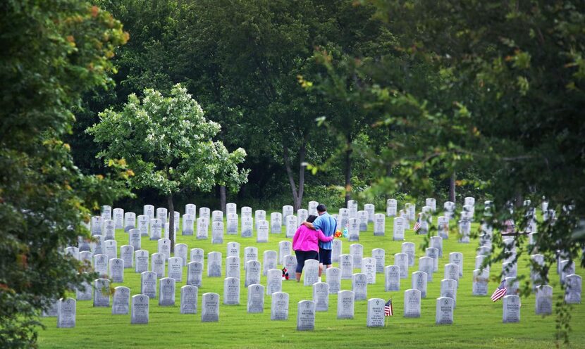 
Danny Rodriguez of Dallas was comforted by his wife, Anna, as he visited the grave of his...