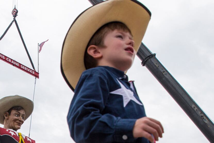 Five-year-old Isaiah Lee of Weatherford talks to his mother as workers raise State Fair of...