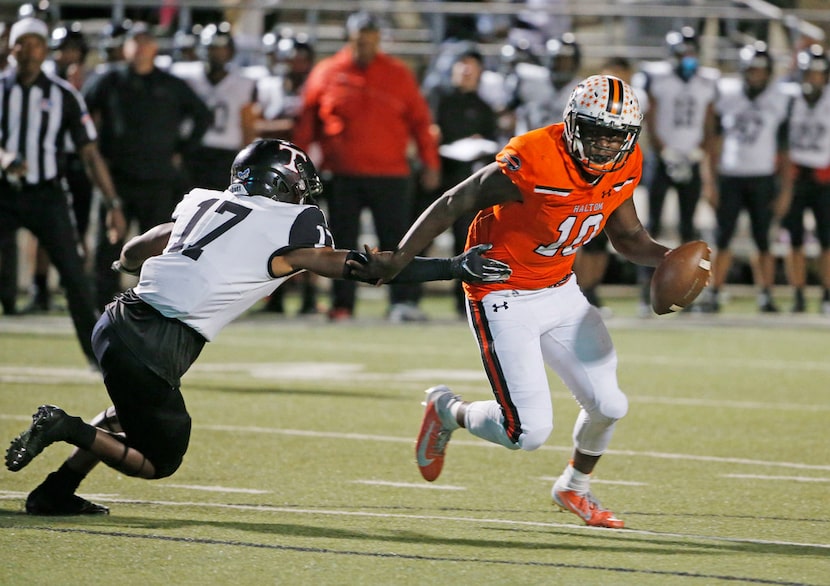 Haltom quarterback quarterback Adam Hill gets away from Trinity defender LDMartin (17) to...