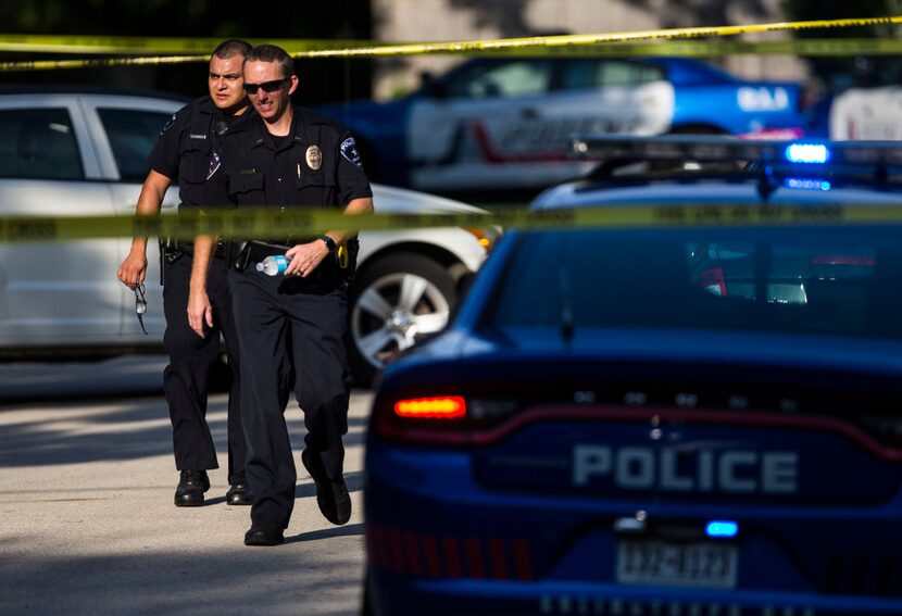 Police work at the scene of an officer involved shooting on Shady Valley Drive, Saturday,...