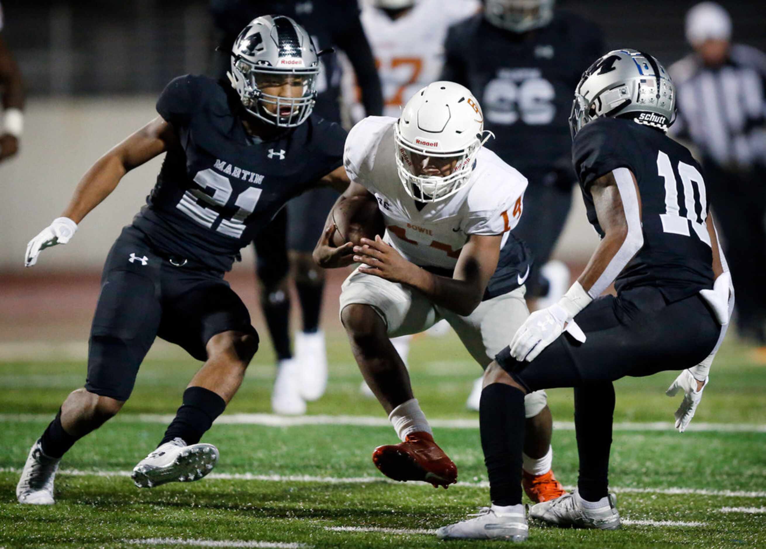 Bowie quarterback Tre Colvin (14) looks to split defenders Martin linebacker Trevell Johnson...