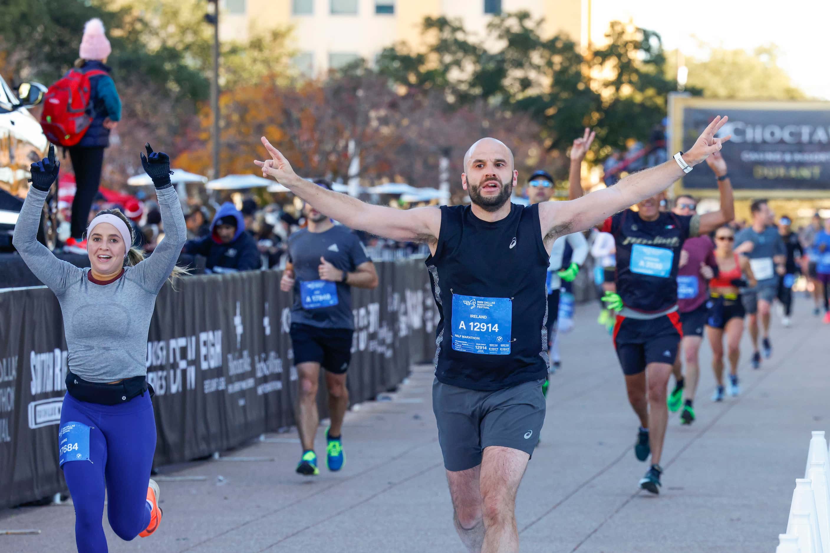 Half marathon finishers cheers as they reach the finish line during 2023 BMW Dallas Marathon...