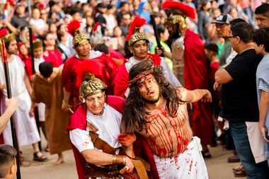 Crowd follows as Bernie Gonzalez playing Jesus Christ is dragged to the cross during Living...