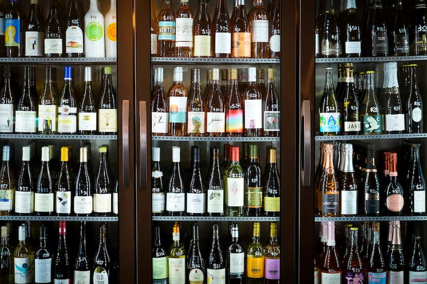 Bottles of wine in a cooler at Neighborhood Cellar, a wine bar in Bishop Arts, on Thursday,...