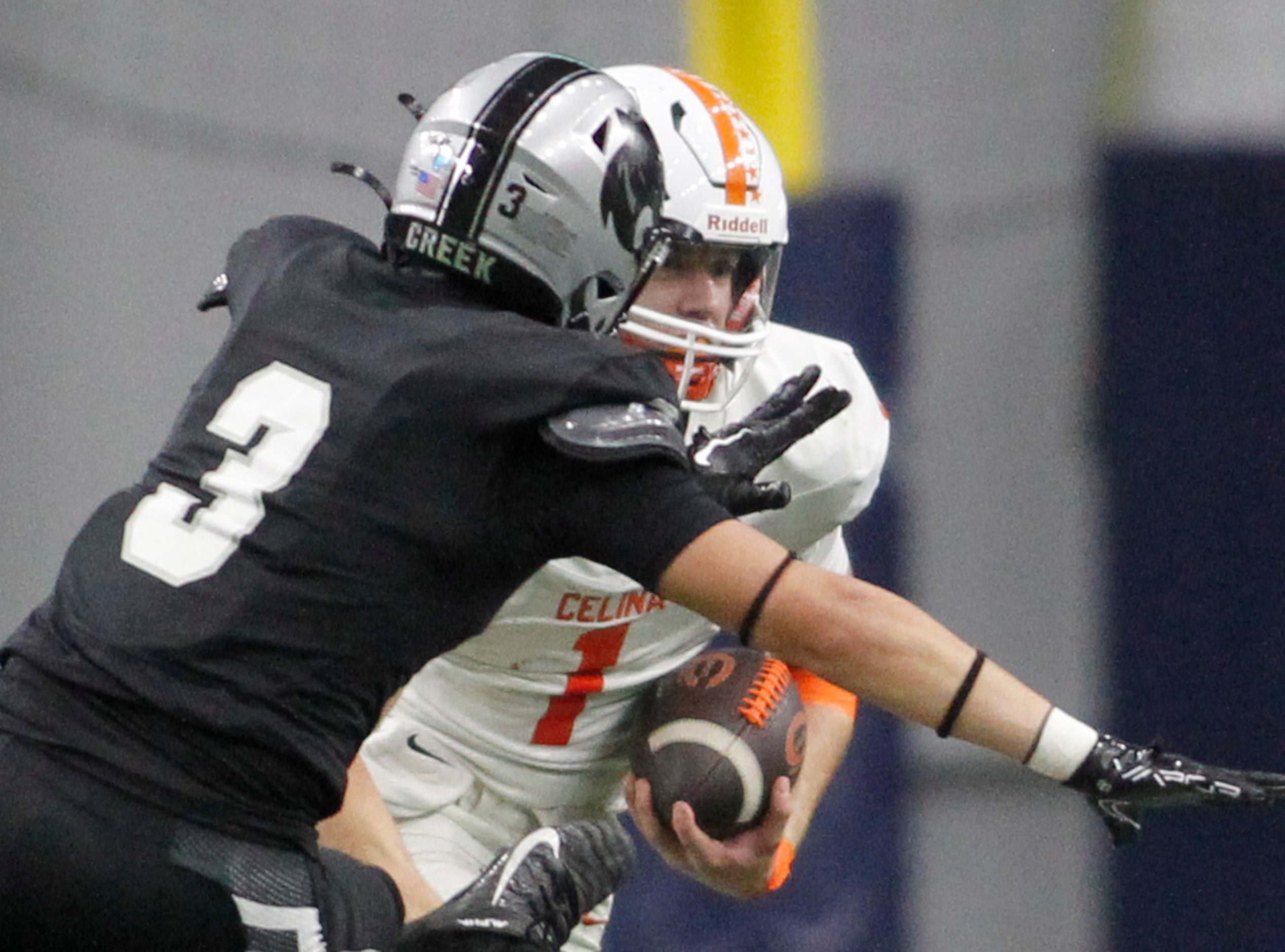 Celina quarterback Bowe Bentley (1), background, looks for running room as he is pursued by...