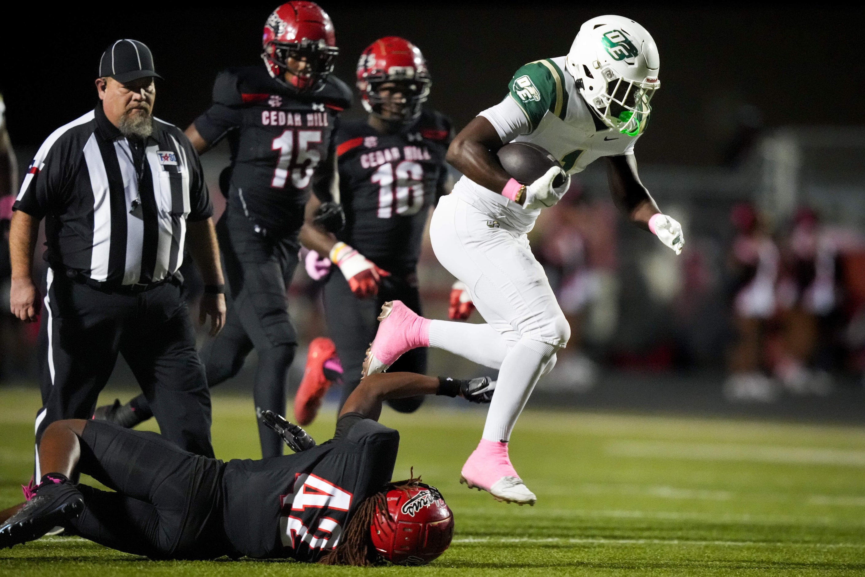 DeSoto running back Deondrae Riden Jr (1) leaps past Cedar Hill defensive back Caleb Jackson...