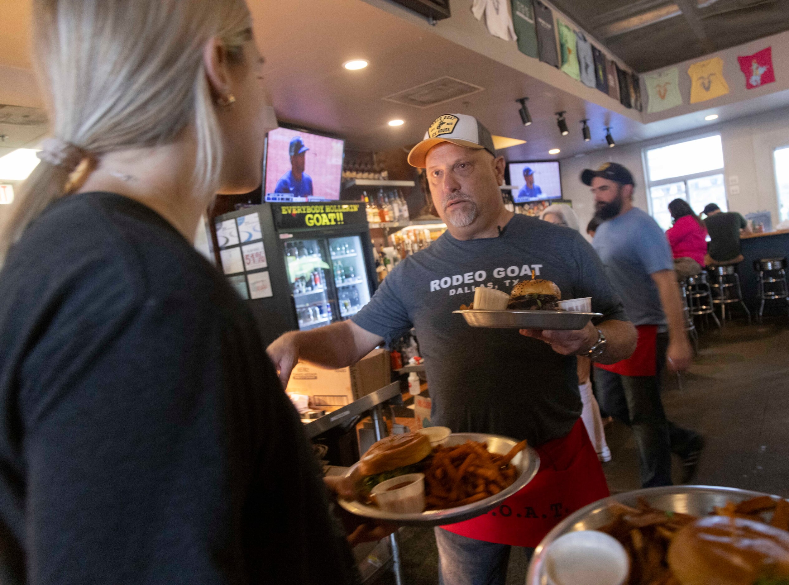 The Dallas Morning News’ Rangers reporter Evan Grant talks to a fellow worker as he carries...