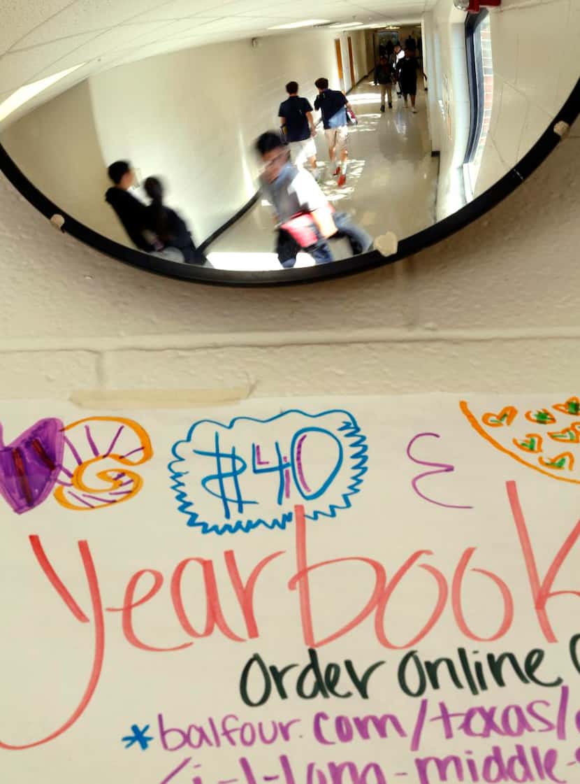 
Students in the hallway are reflected in a rounded mirror at J.L. Long Middle School....