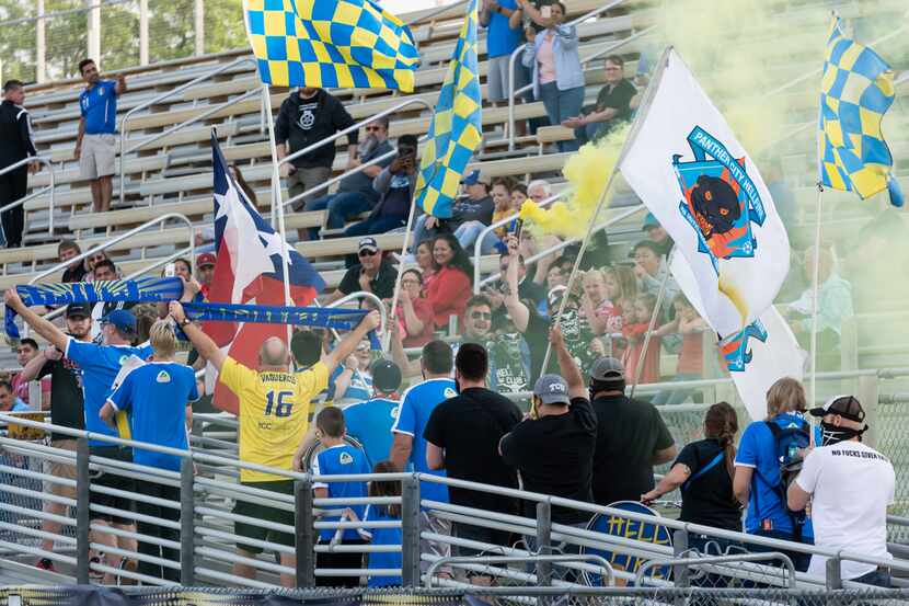 Vaqueros supporters group Panther City Hellfire march into the stands at Denton High School...