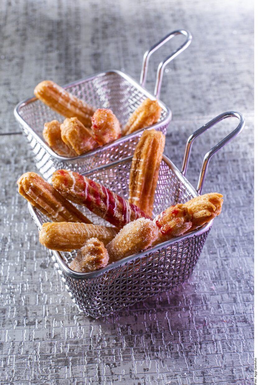 Use una taza de chocolate blanco fundido para acompañar a los churros como decoración.