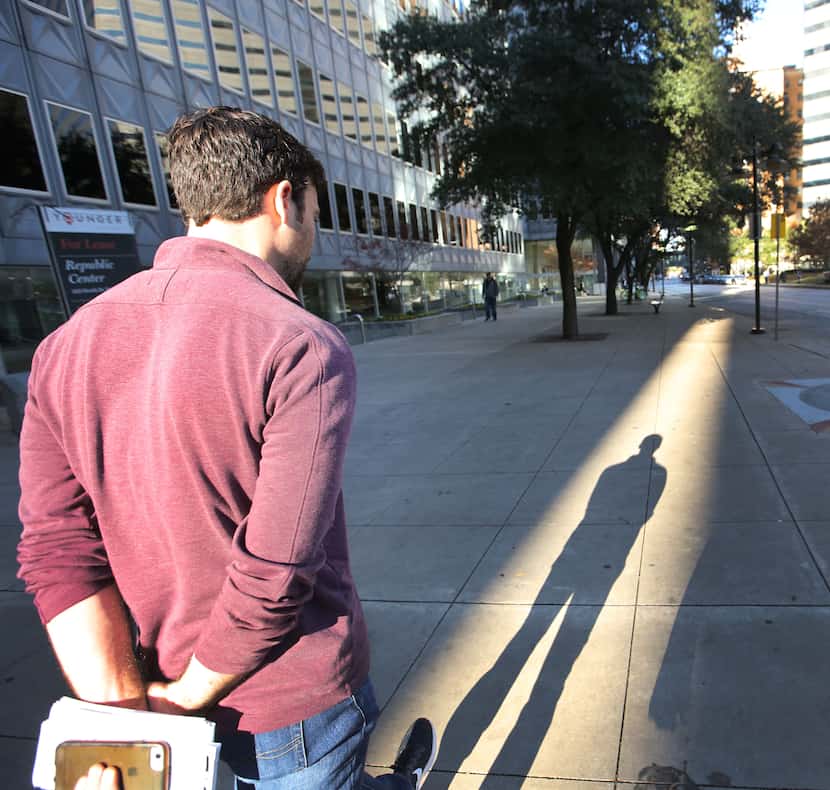 Dallas Morning News reporter Brendan Meyer walks from the office on Commerce Street to St....