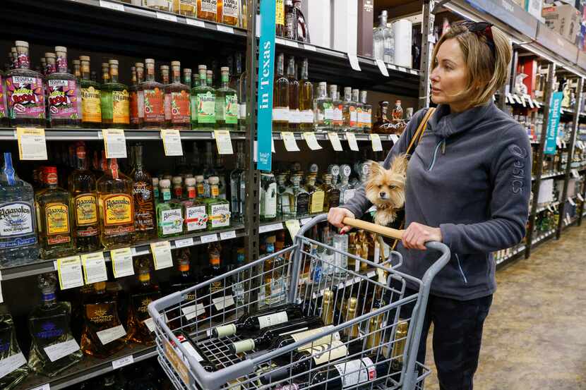 Gina García, de 52 años, compra con su perra Nala en una tienda Total Wine & More en Dallas,...