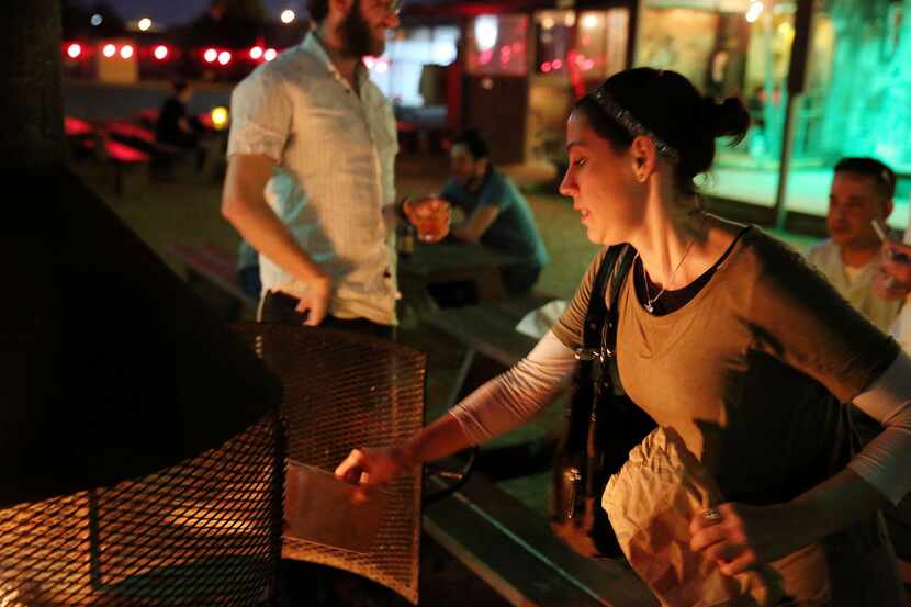  Caitlin Fehrenbacher, of Dallas, throws flour into a fire during the Intown Chabad's...