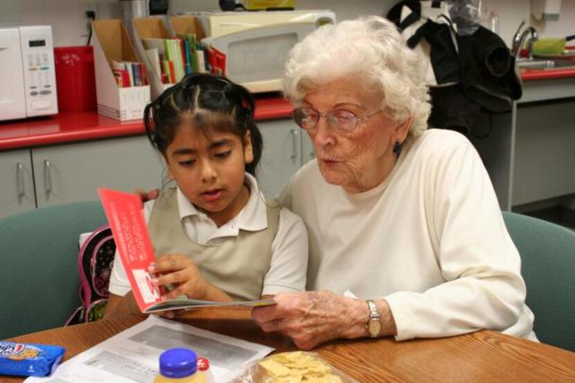 
Emeritus at Farmers Branch resident Joan Hinton, 85, helps Maria Jose, 6, a student in...