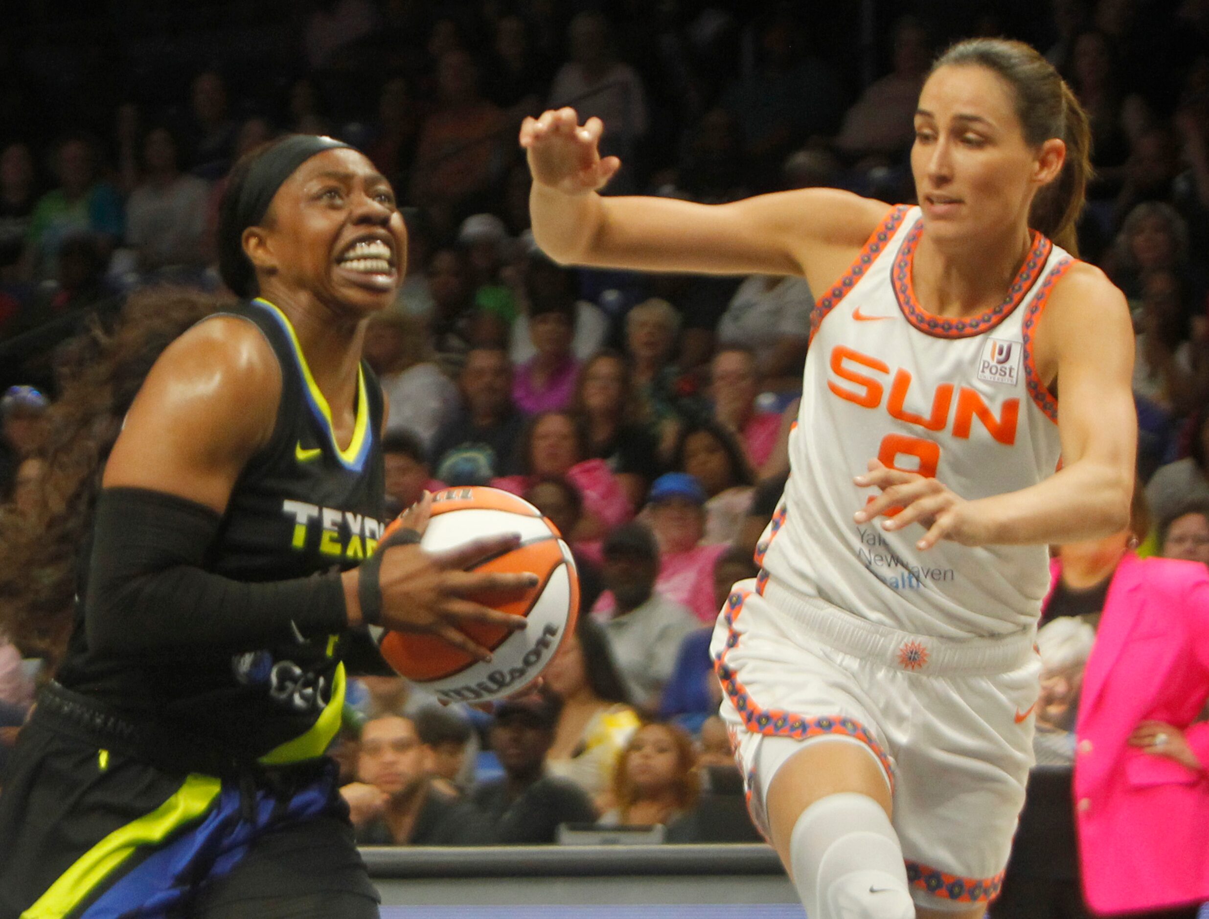 Dallas Wings guard Arike Ogunbowale (24) drives past Connecticut Sun guard Rebecca Allen (9)...