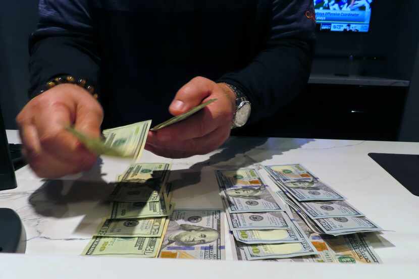 A sports book clerk counts money at the Ocean Casino Resort in Atlantic City, N.J., Monday,...