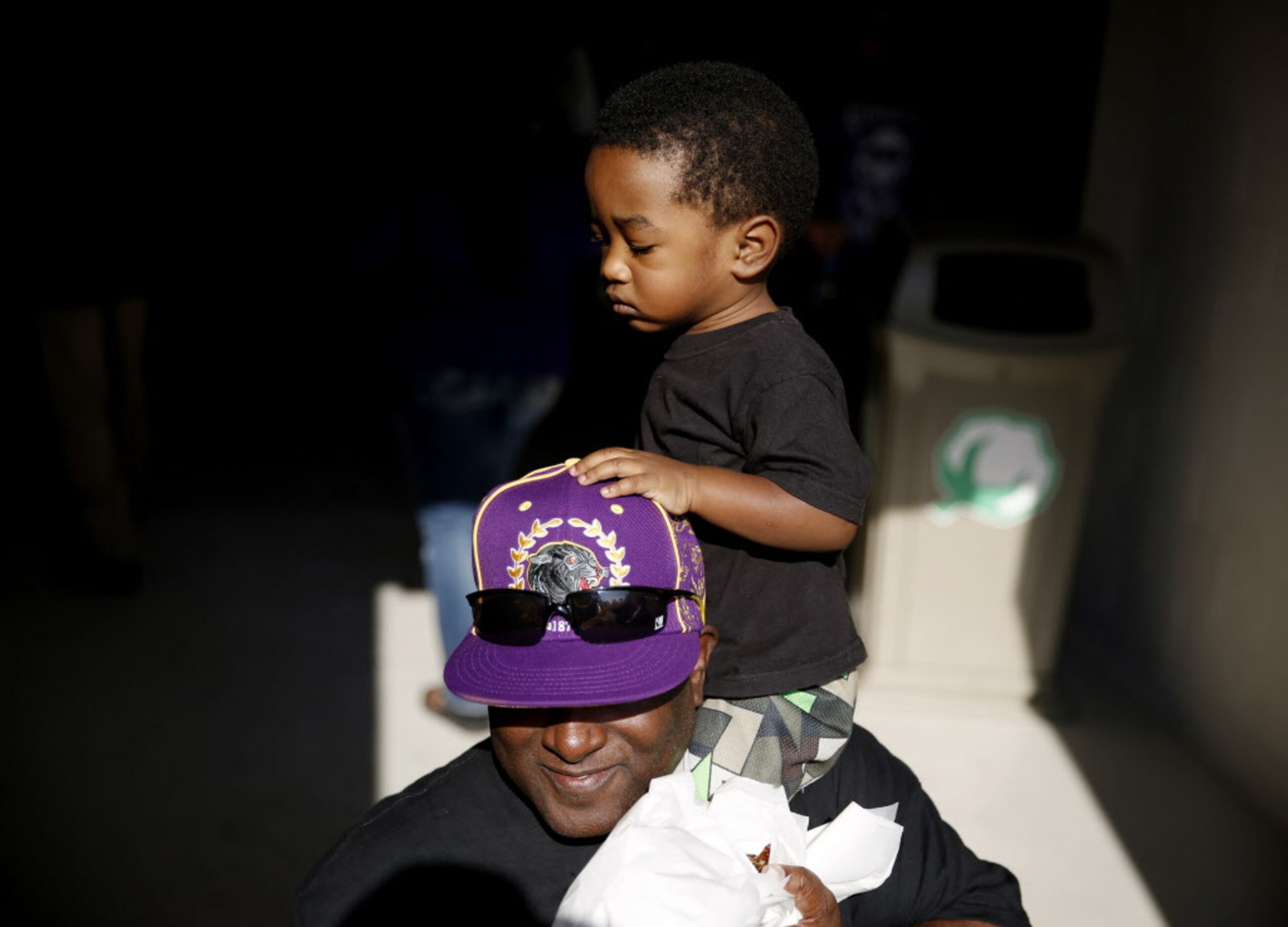 Xavier Curley is perched on his father's shoulders, James Curley, of Fort Worth, while...