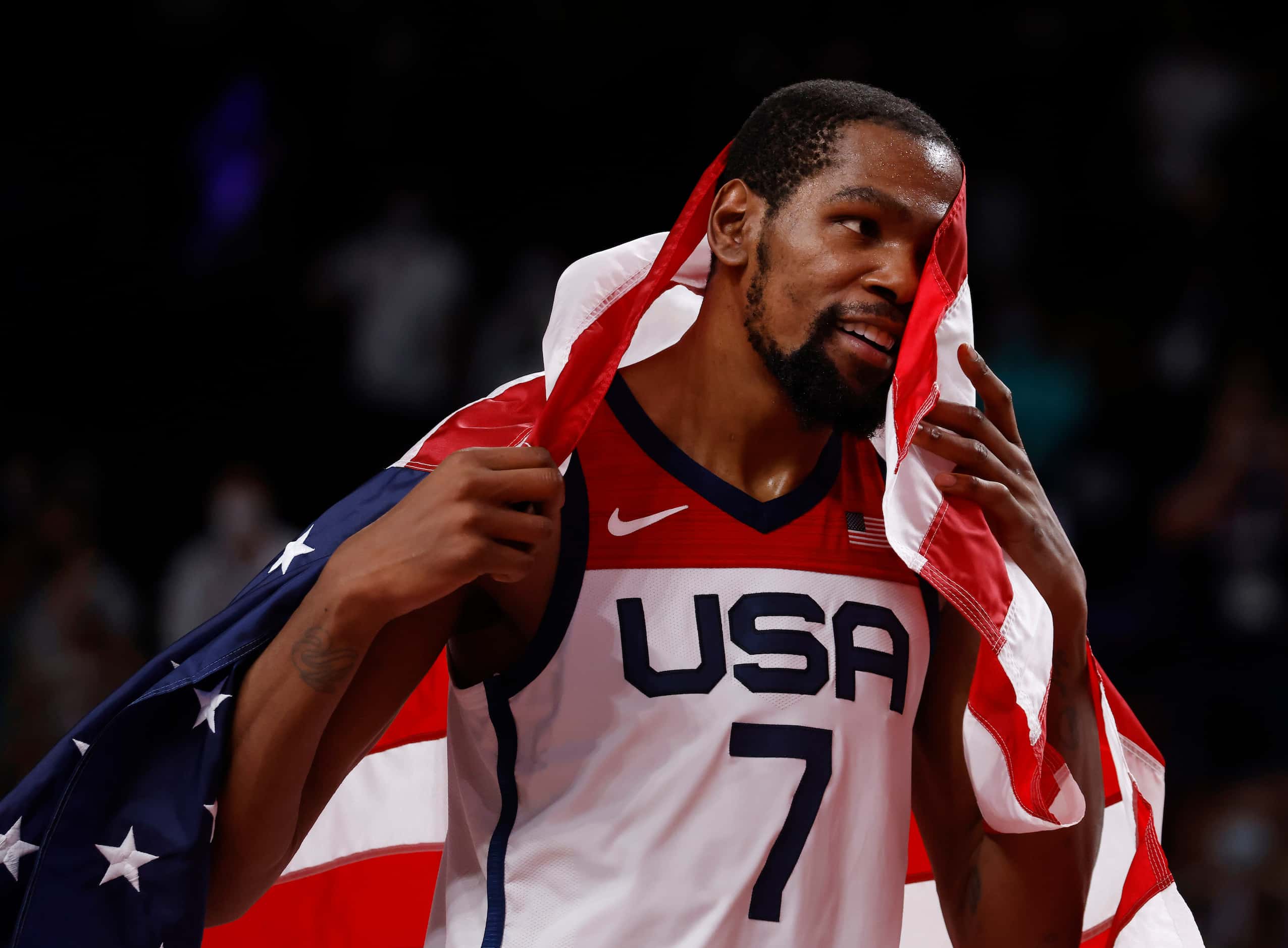 USA’s Kevin Durant (7) drapes a flag around himself in celebration after defeating France in...