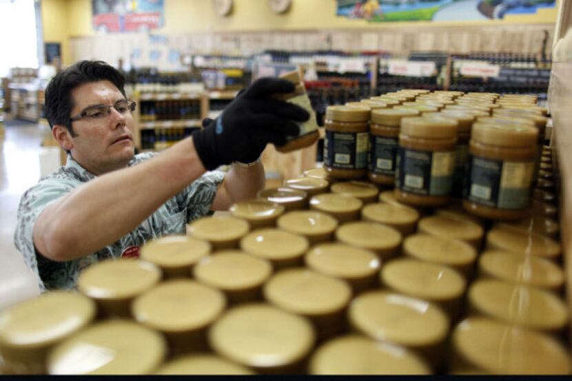 Garth Olson stacks cookie butter up for a display at Trader Joe's in Plano on September 6,...