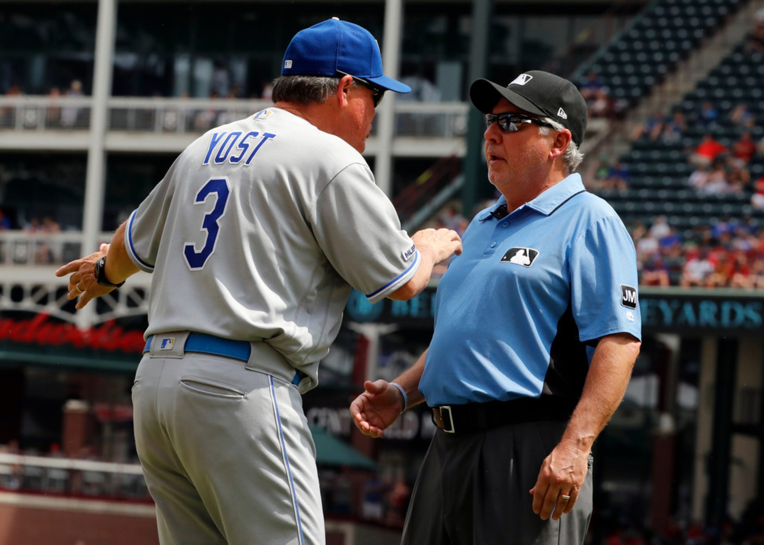 Kansas City Royals' Ned Yost, left, talks with crew chief Tom Hallion, right, after a Texas...