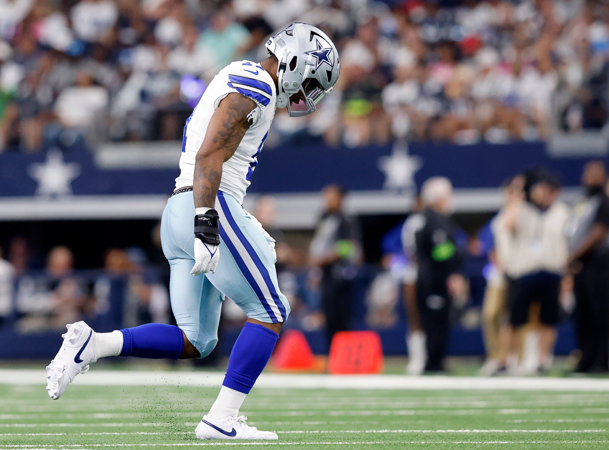 Dallas Cowboys linebacker Micah Parsons (11) limps back to the sideline after coming back in...