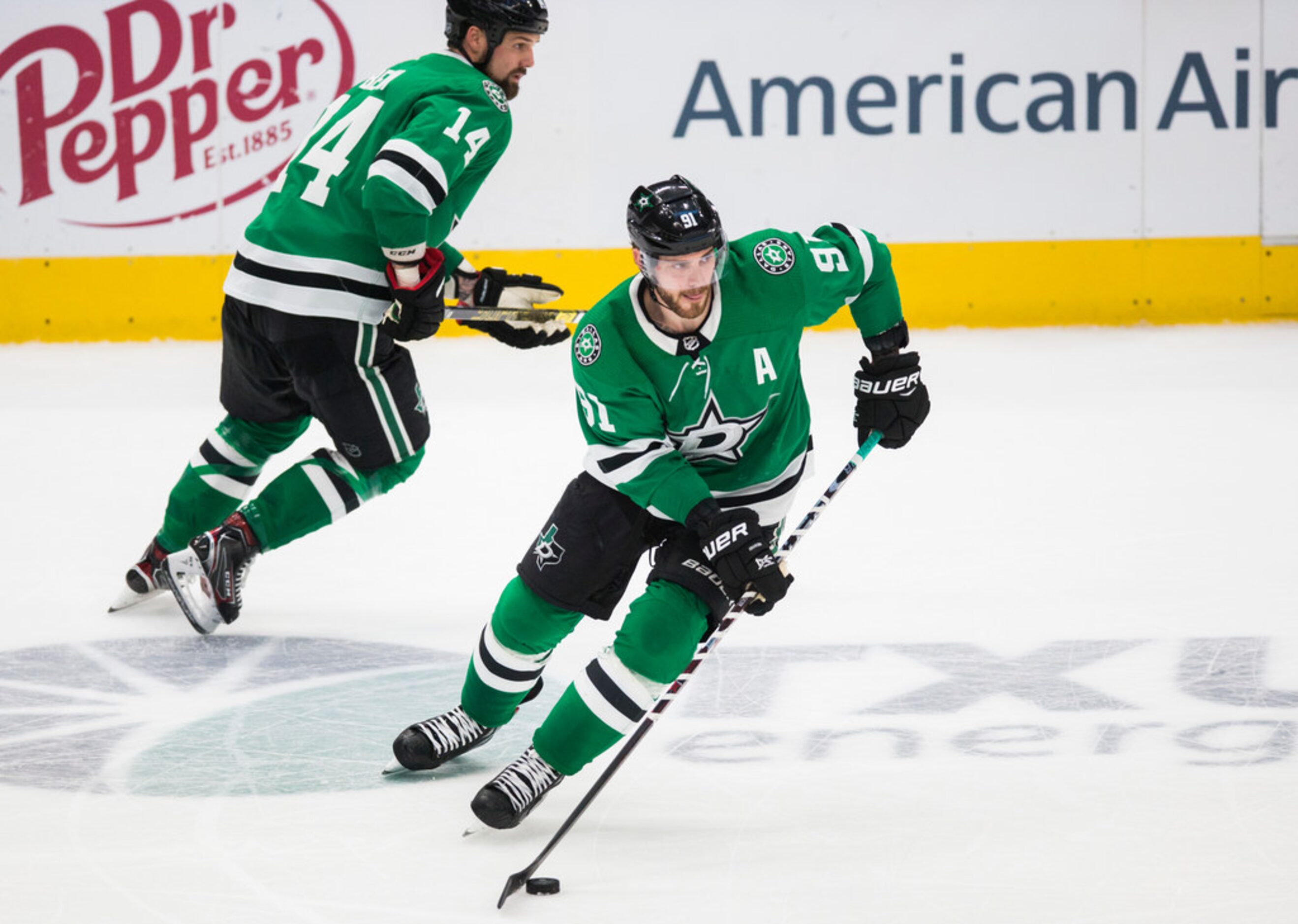 Dallas Stars center Tyler Seguin (91) and left wing Jamie Benn (14) make their way down the...